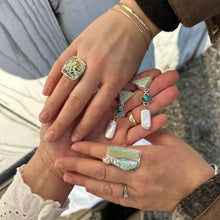 Load image into Gallery viewer, Two hands holding various rings with a natural background
