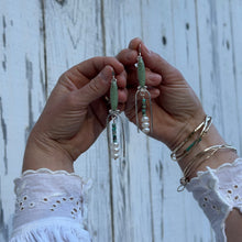 Load image into Gallery viewer, Hands holding jewelry on a wooden surface
